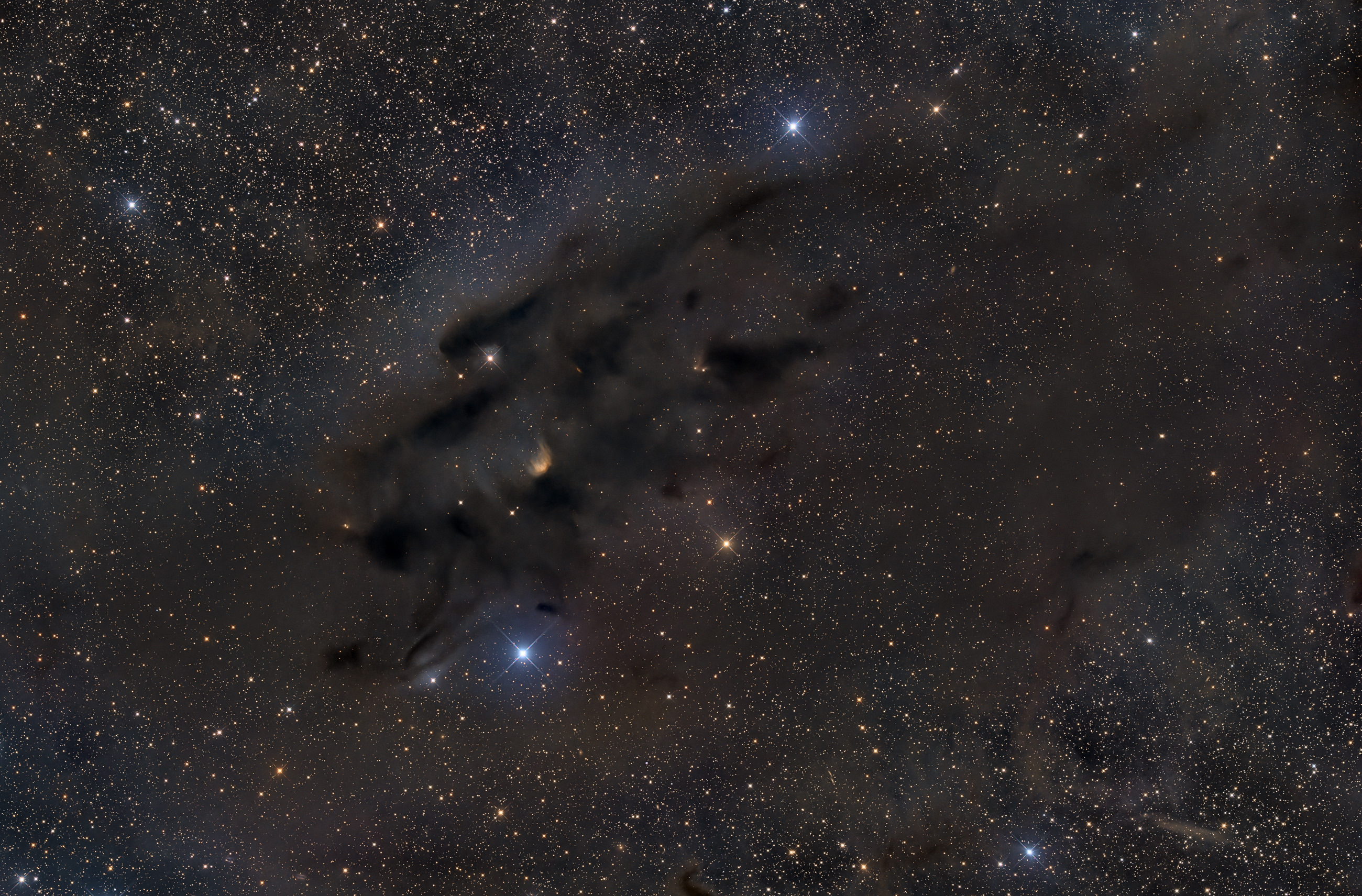 IC 2087 is a small emission nebula in the center of the dark nebula Barnard 22. This is part of the Taurus molecular cloud.